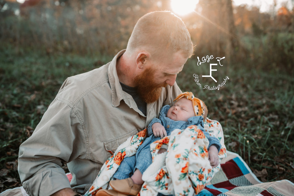 dad holding baby girl looking at her