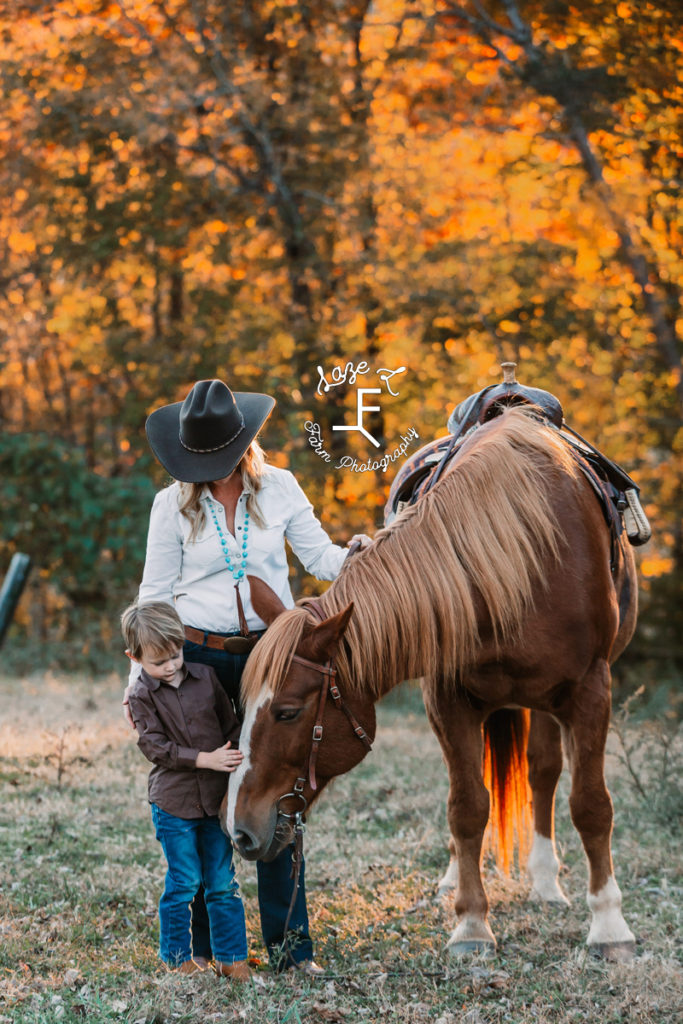mom and son standing with horse