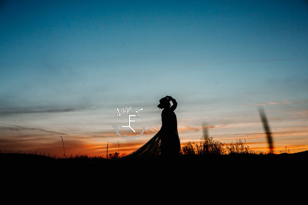 bride silhouette with hat at sunset