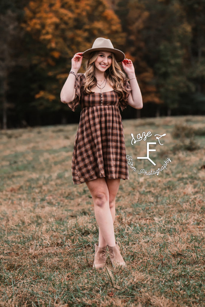 senior girl in brown plaid dress with hat