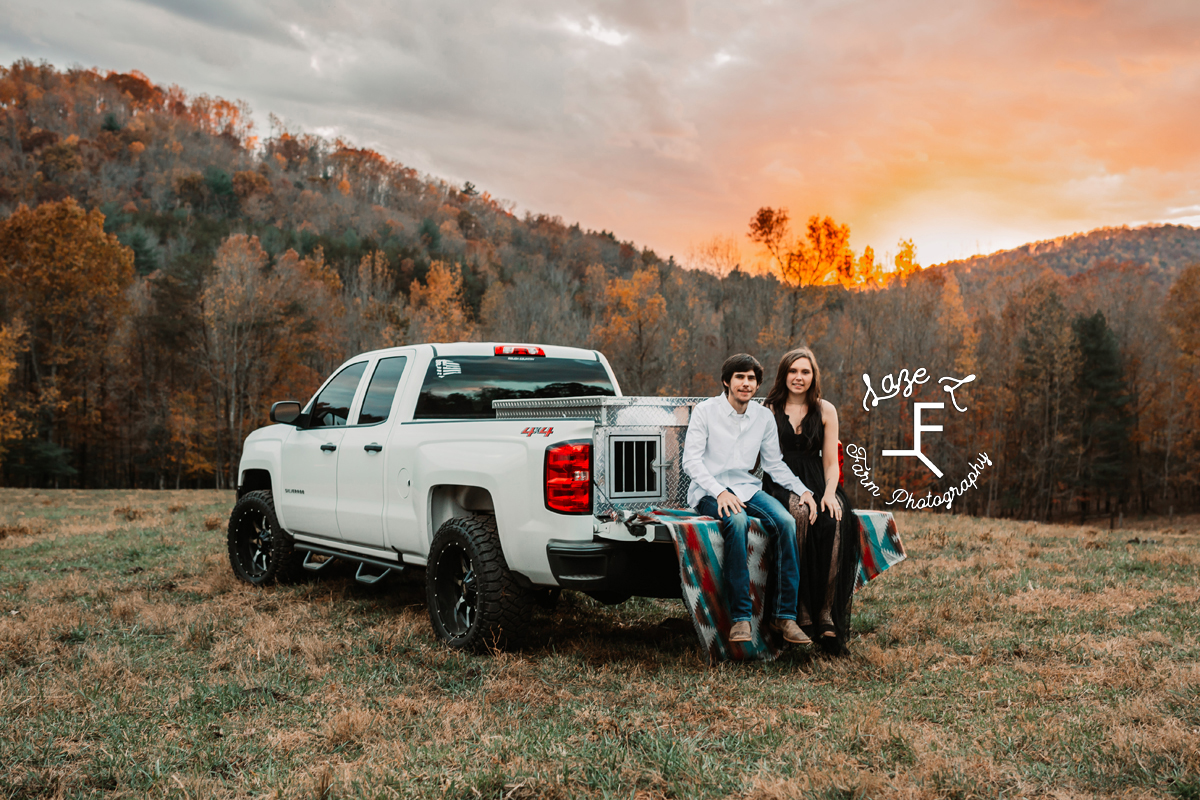 couple sitting on back of chevy truck at sunset