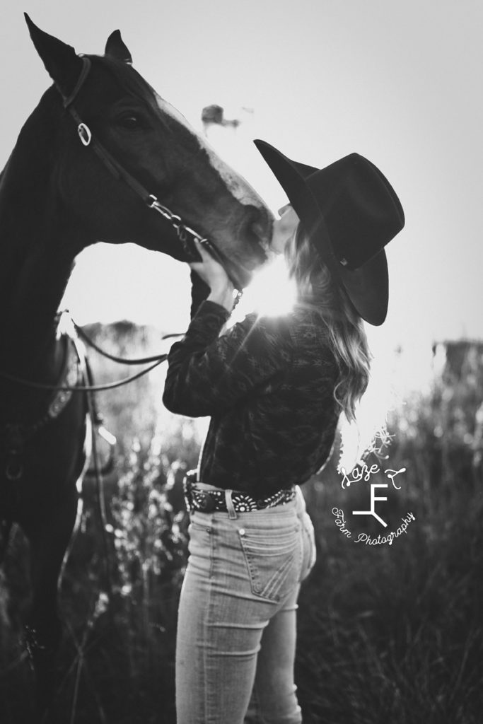 cowgirl loving on horse in black and white
