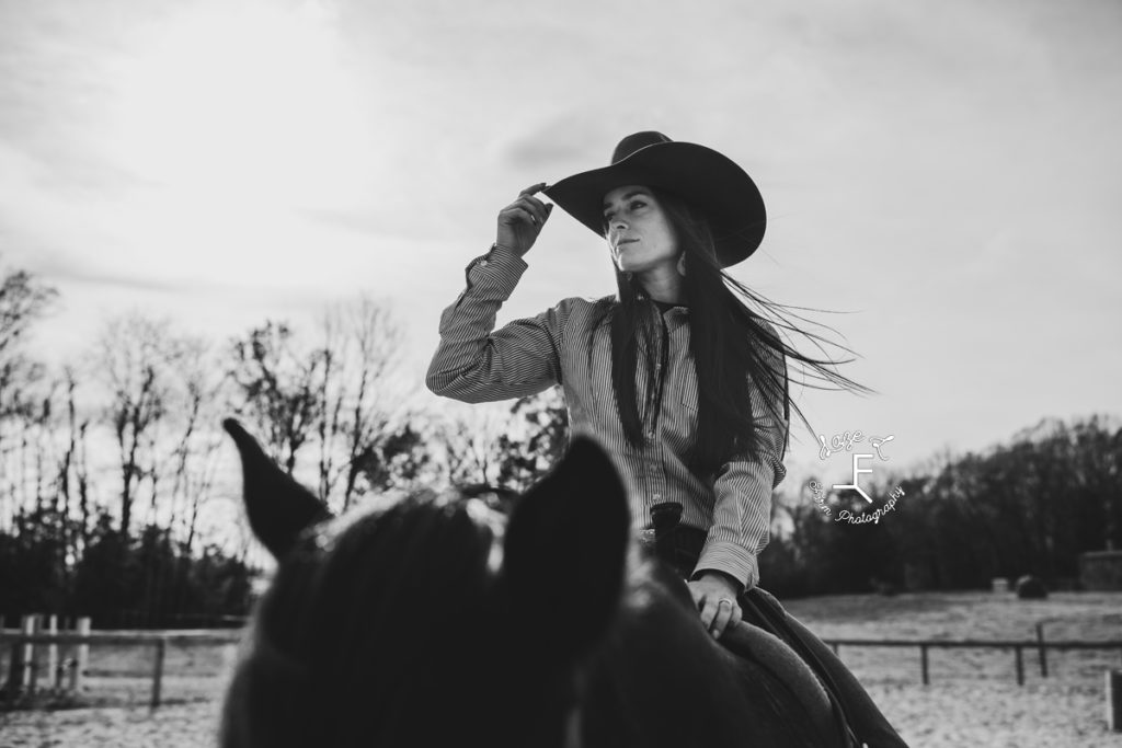 cowgirl in black felt hat in black and white