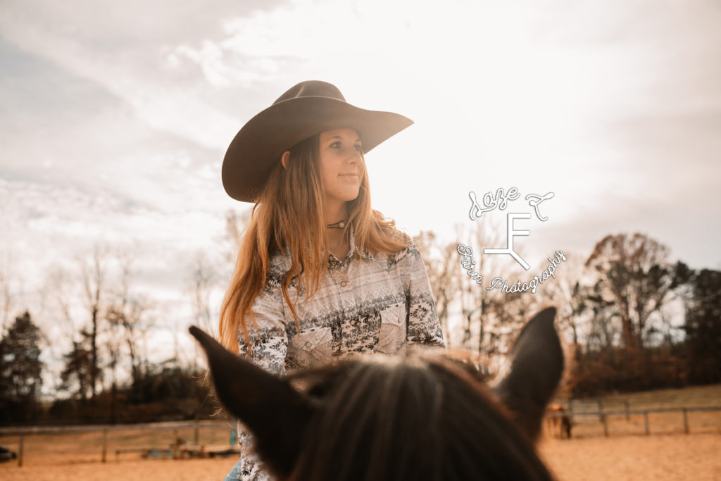 cowgirl between horses ears looking away