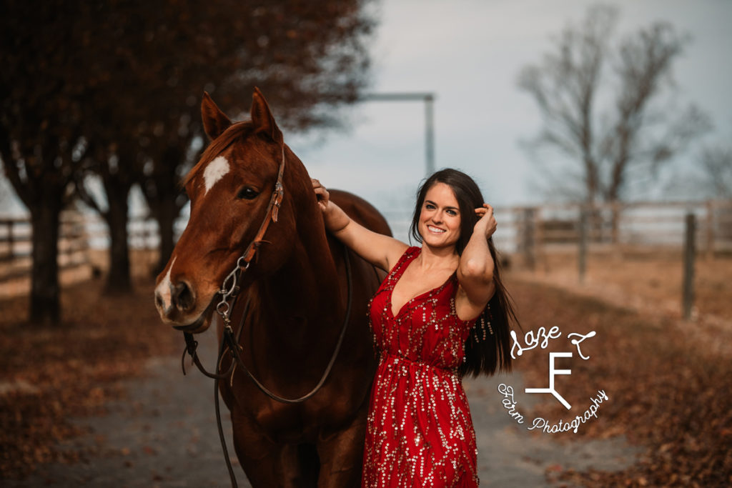 brunette in red dress with red sorrel mare