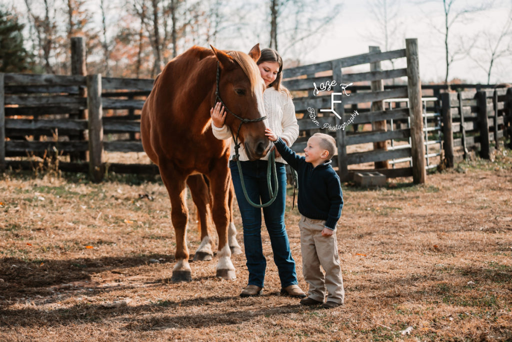 big sister and little brother with horse