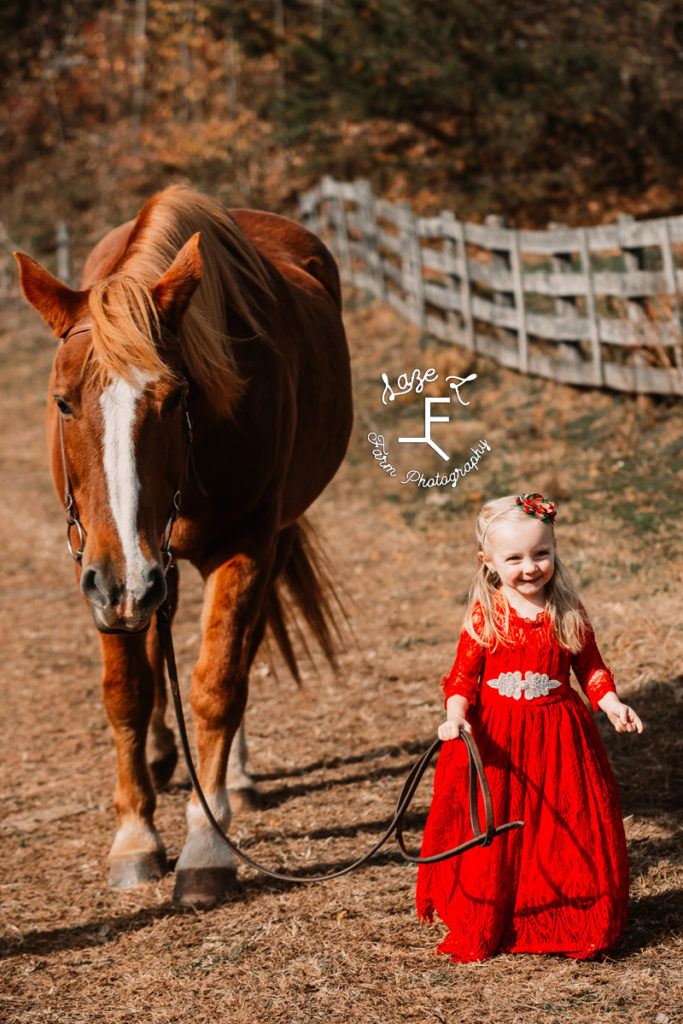 blond hair little girl walking big horse