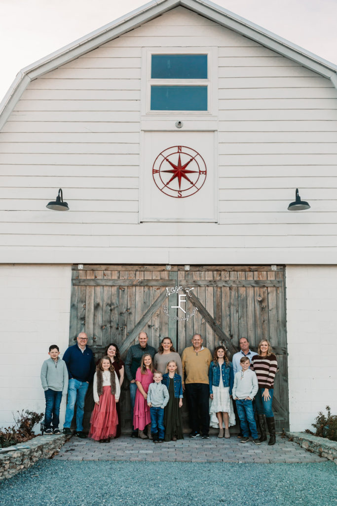 large family in front of barn