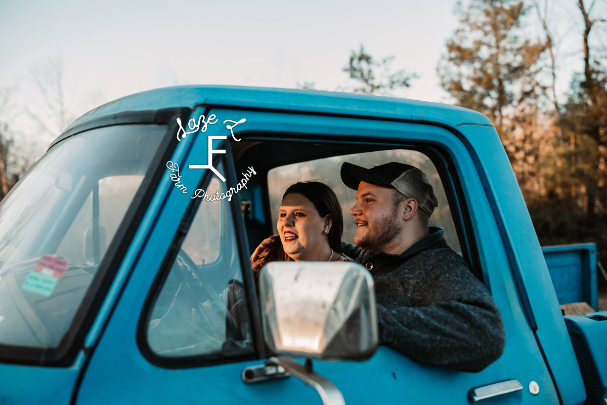 couple riding in blue truck
