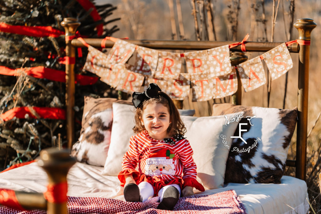 little girl with merry christmas sign