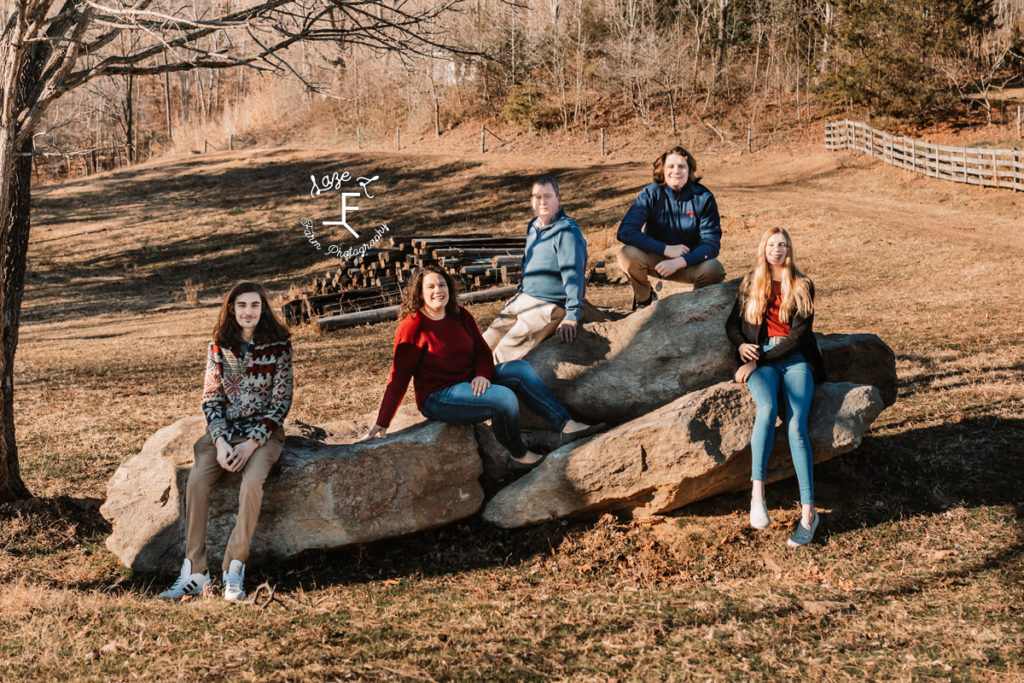 Family of 5 sitting on rock