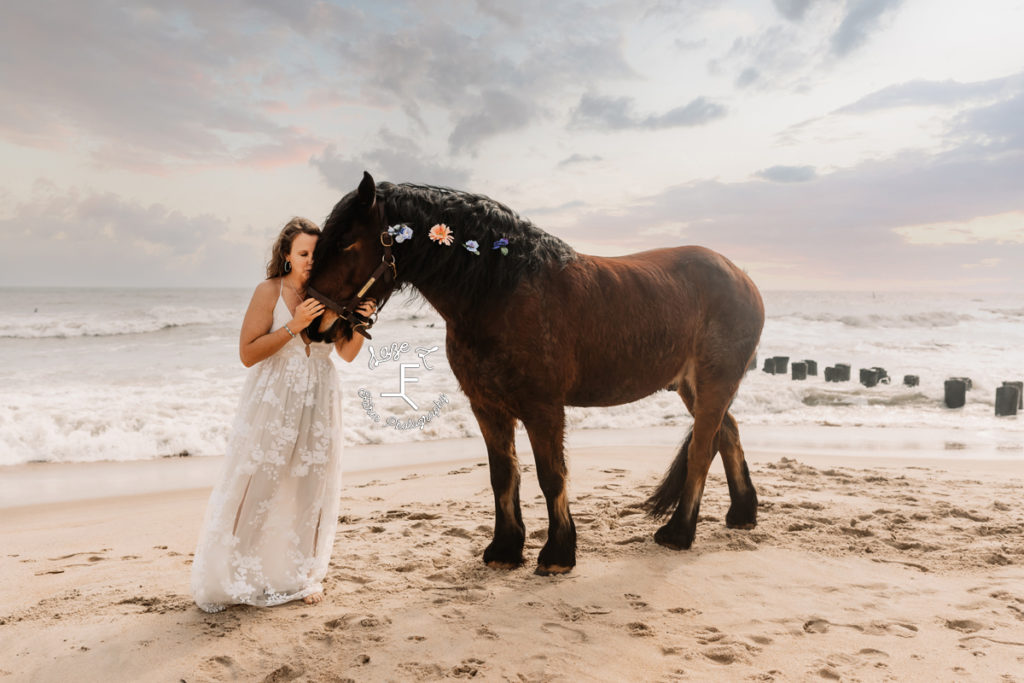 shire horse with flowers in mane with girl in white