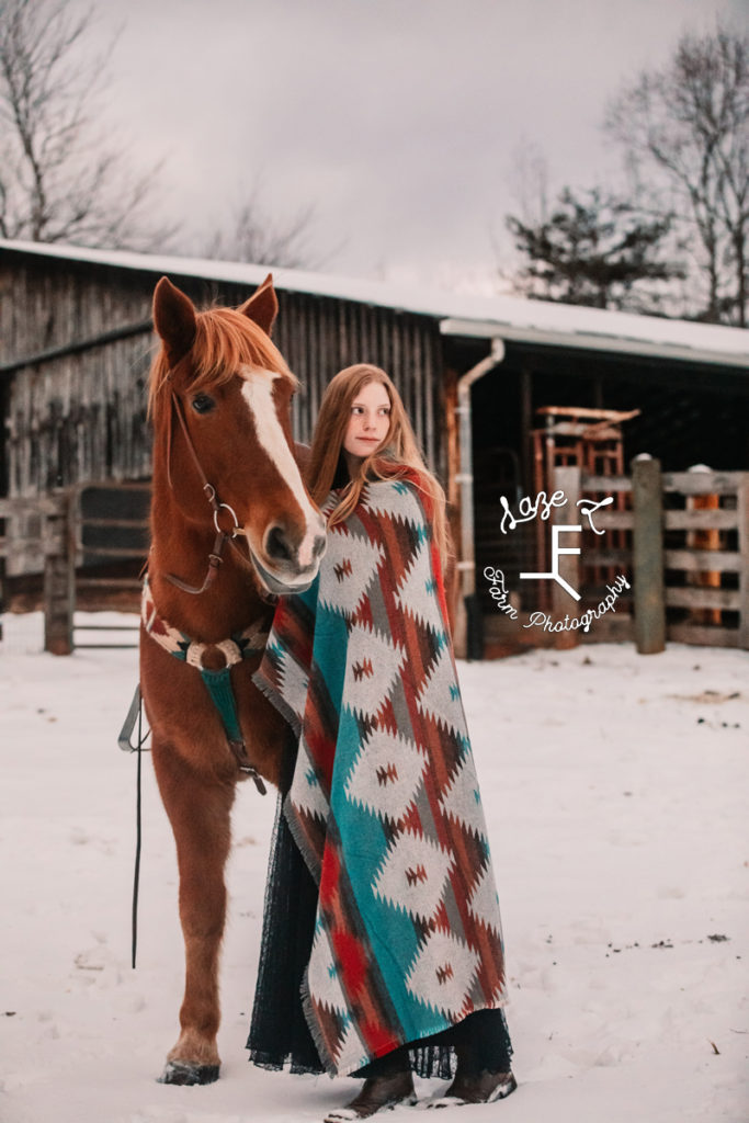 redhead with horse wrapped in a blanket