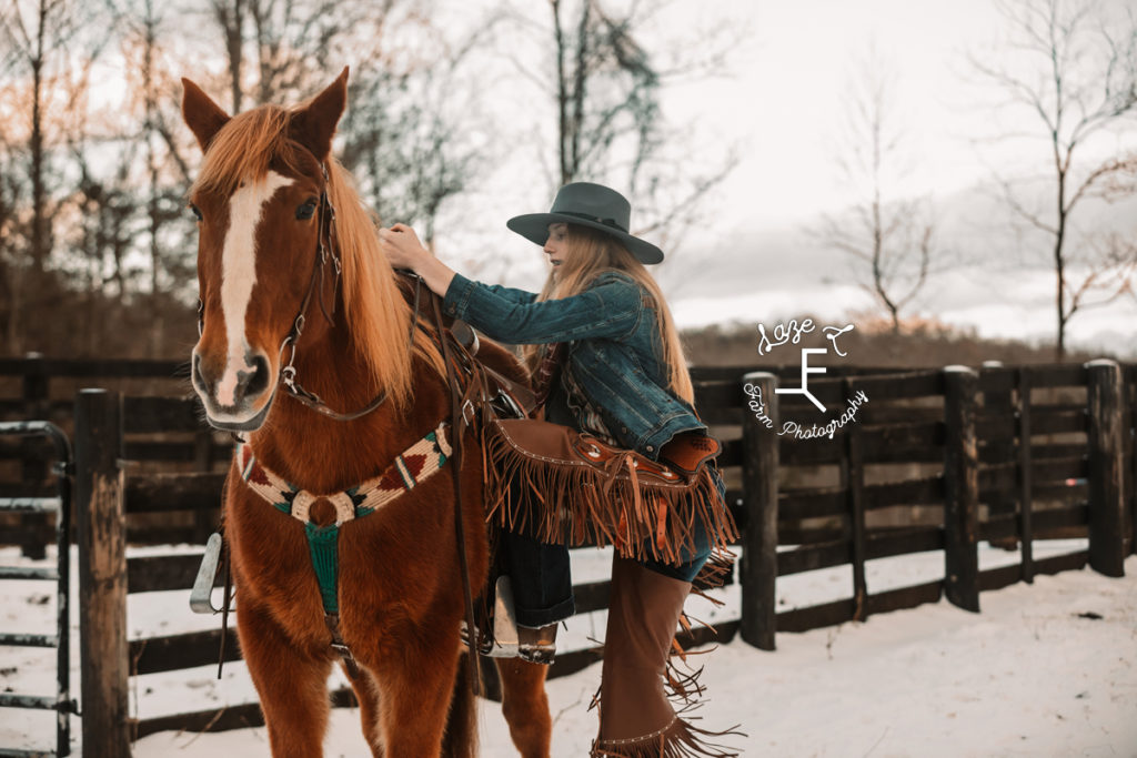 redhead cowgirl getting on horse