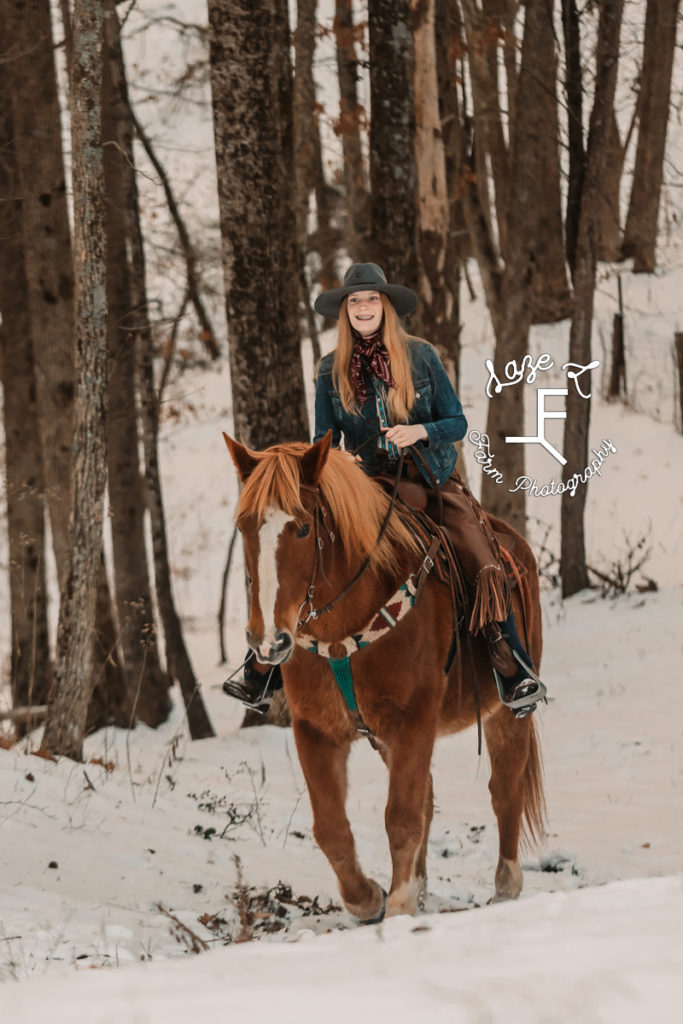redhead cowgirl riding in the snow