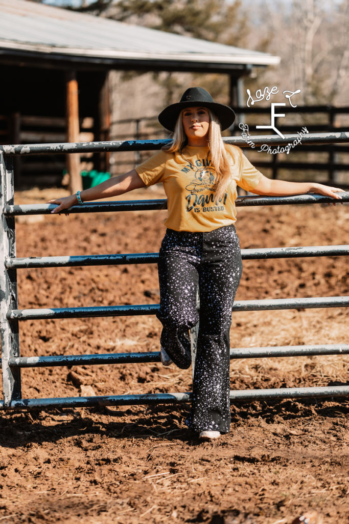cowgirl on fence in black star wranglers