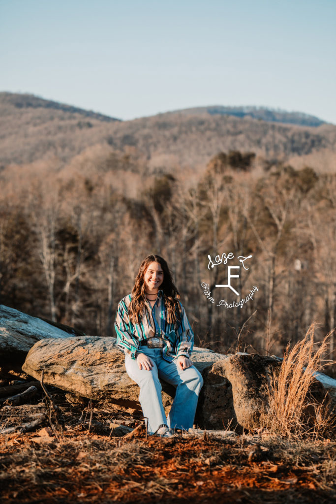 girl sitting on rocks in vintage western shirt