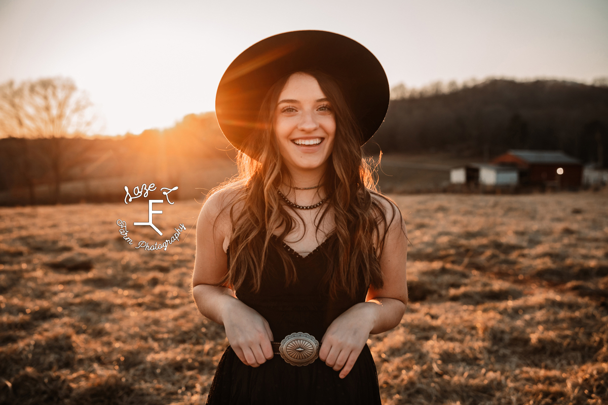 cowgirl in black dress at sunset