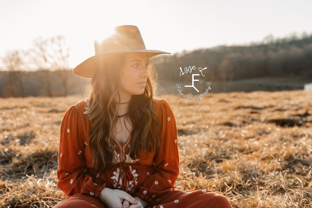 girl in orange dress sitting with cowboy hat on