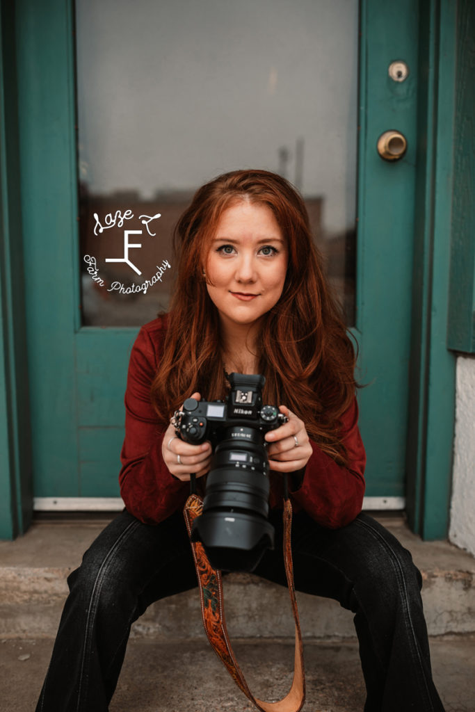 red haired photographer reviewing images on camera