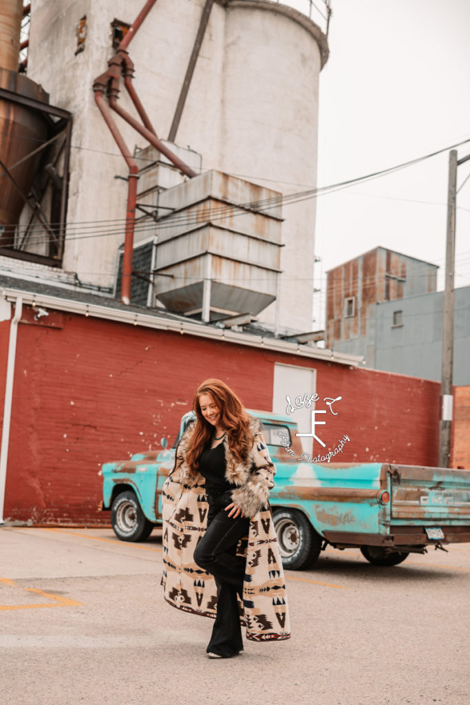 red head in fur coat in industrial setting