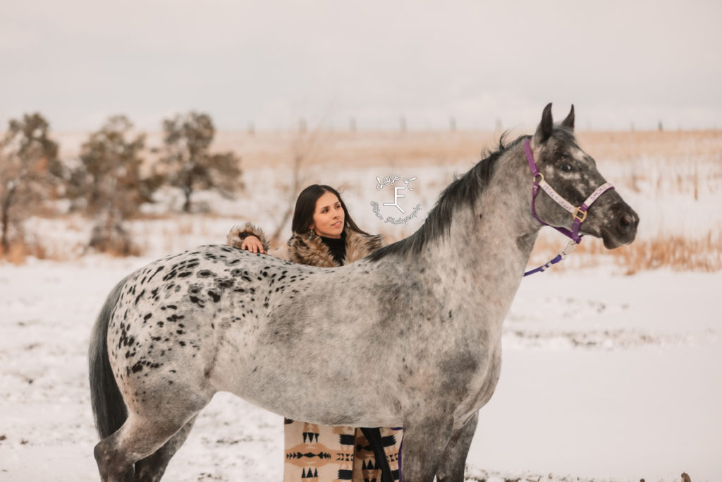 horse standing for side profile while girl is behind