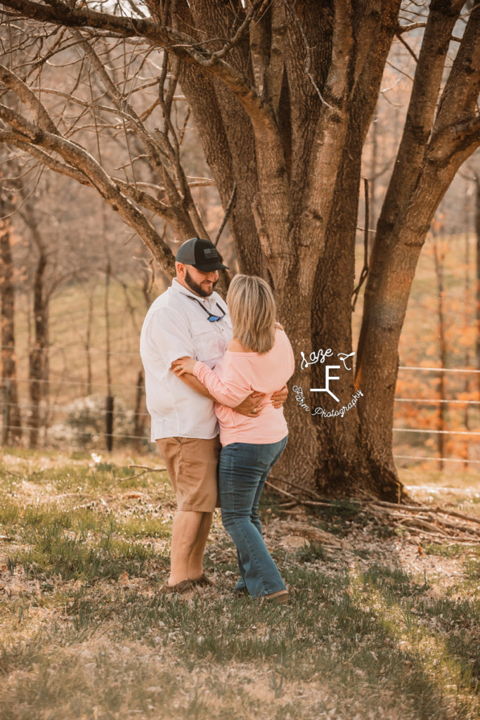 couple looking at each other under tree