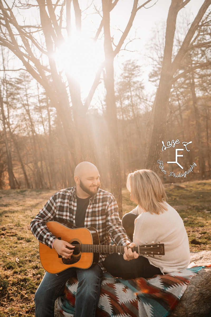 guy playing guitar to girl with light behind them