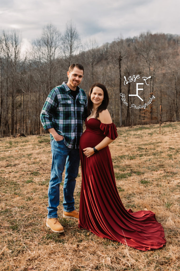 couple with pregnant wife in long red dress