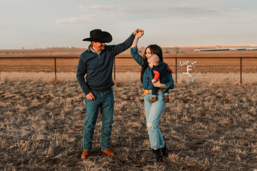 western mama and dad dancing while she holds baby