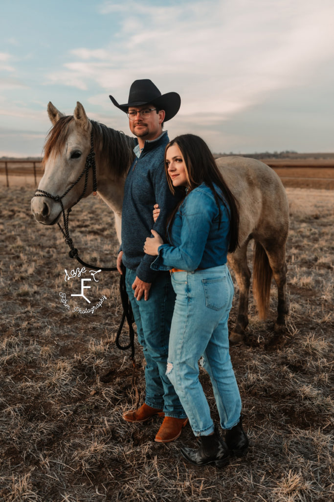 western couple with horse cowboy looking at camera