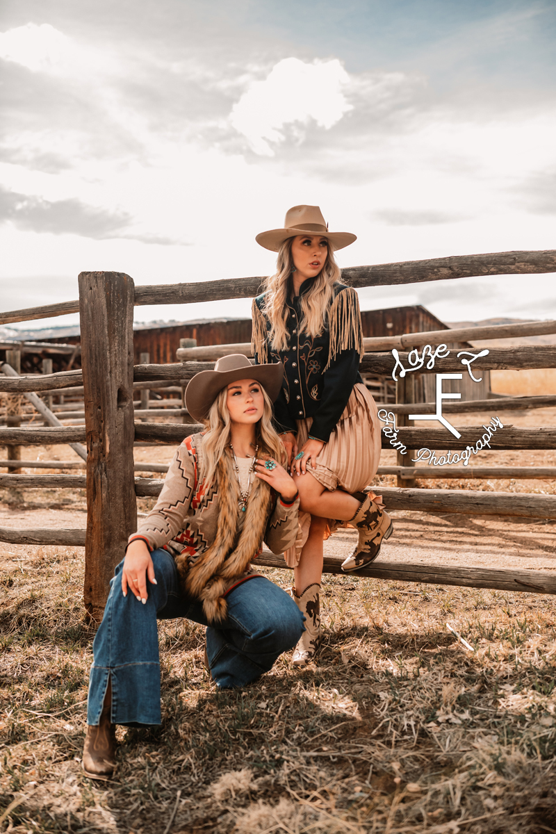 2 blonde cowgirls posing on wood fence in western fashion