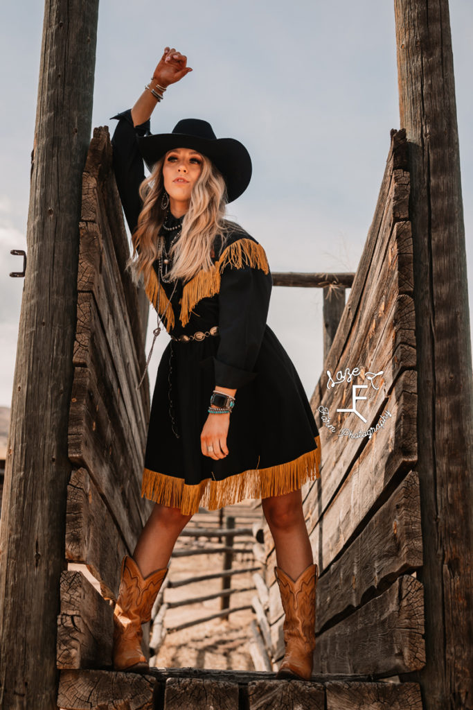 blonde cowgirl in wood slat fence