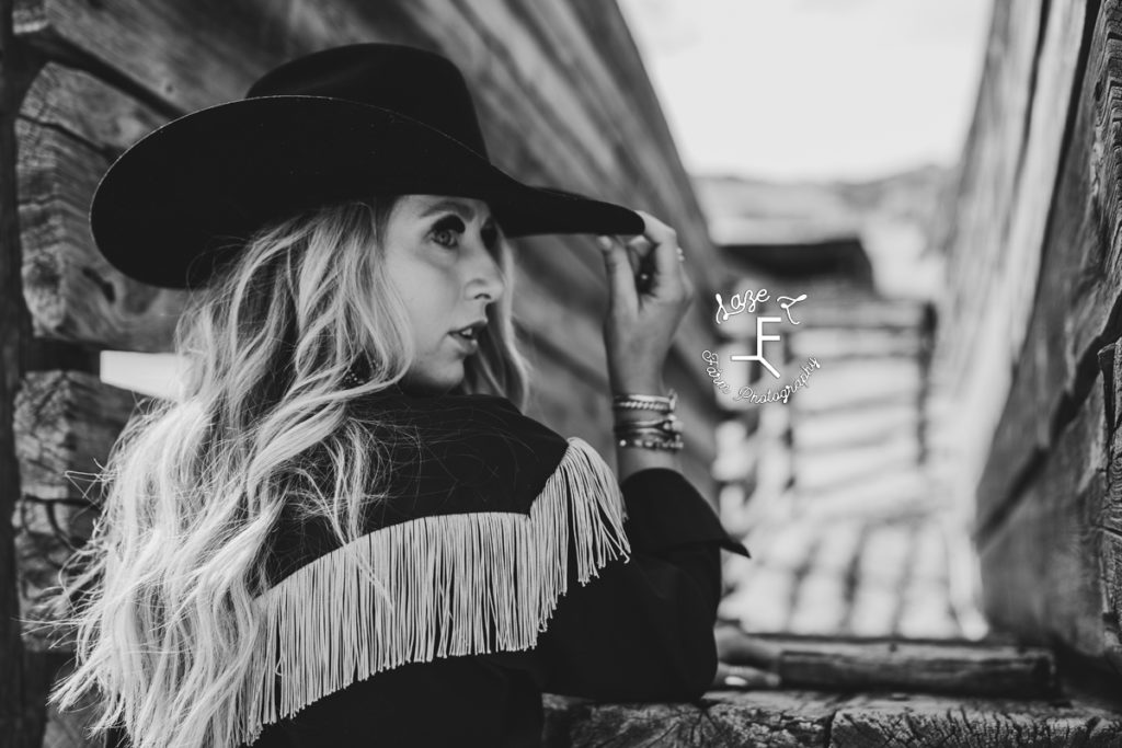 blonde cowgirl in fringe dress in black and white