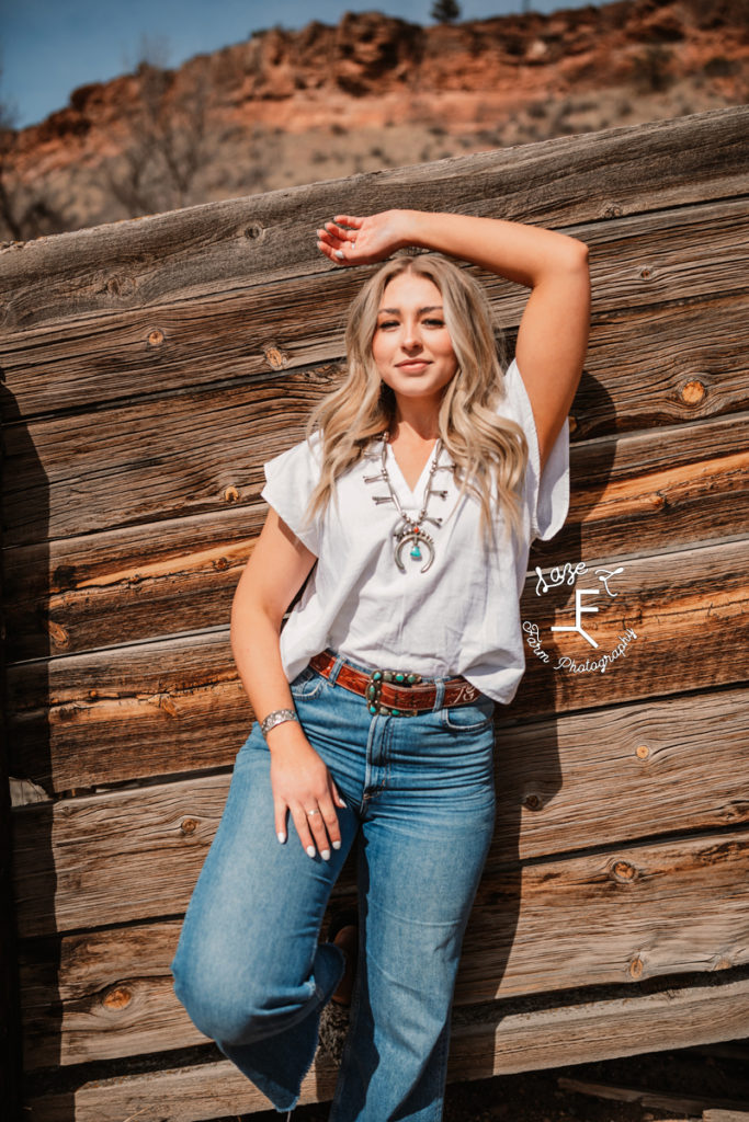 blonde model in western fashion against wood fence