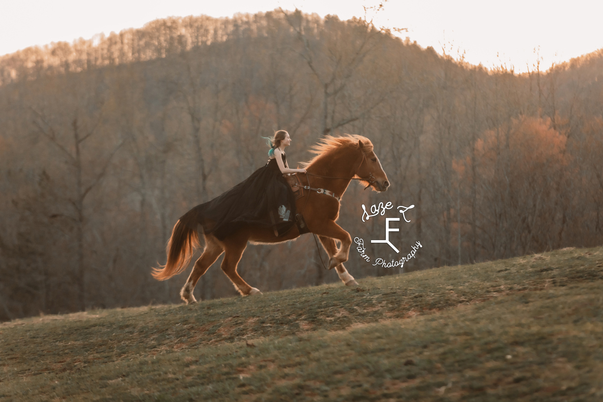 teen girl in black dress loping up hill on horseback