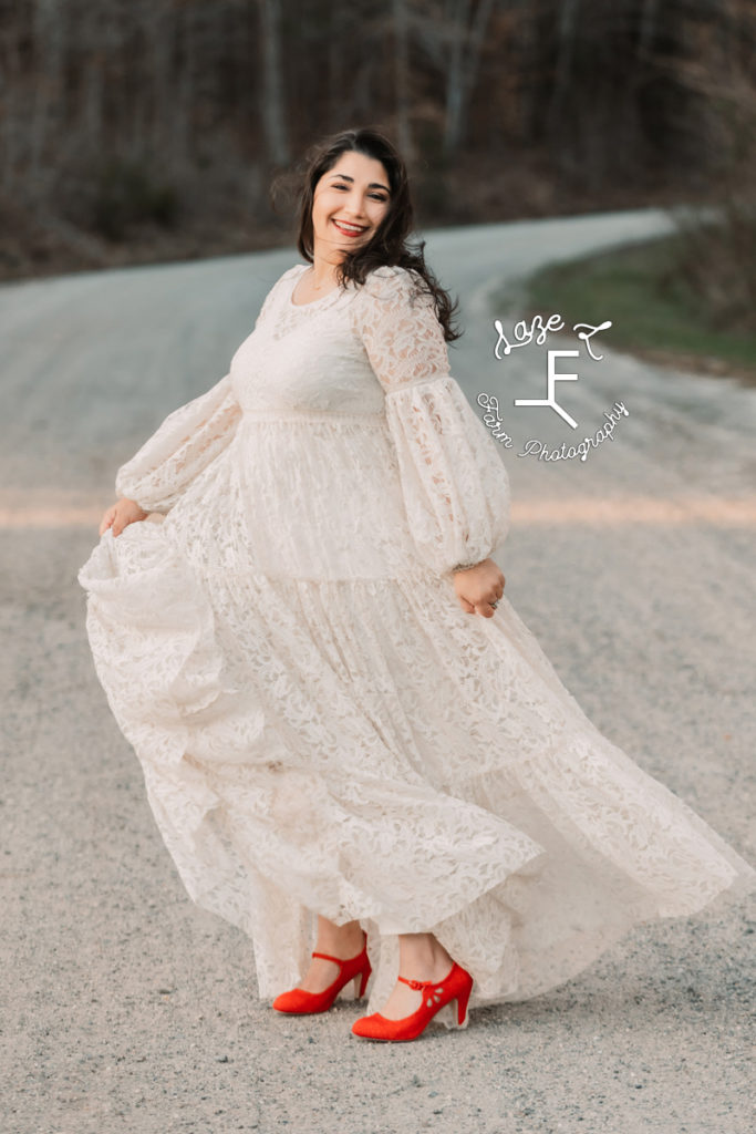 girl in a lace dress with red shoes on a dirt road