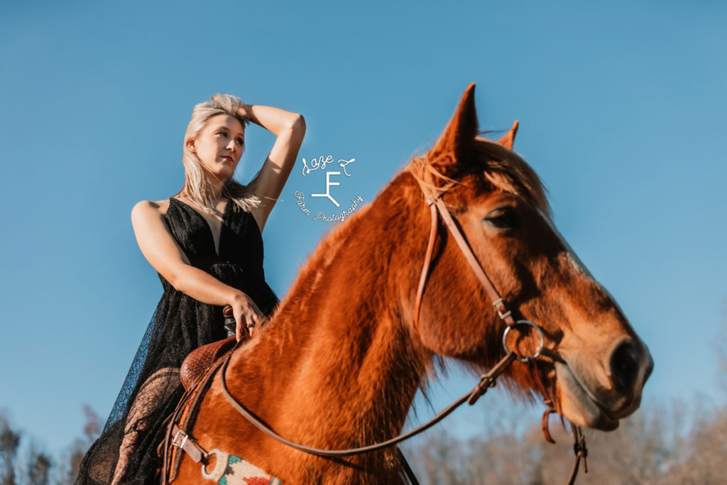 blonde girl in black dress on horse