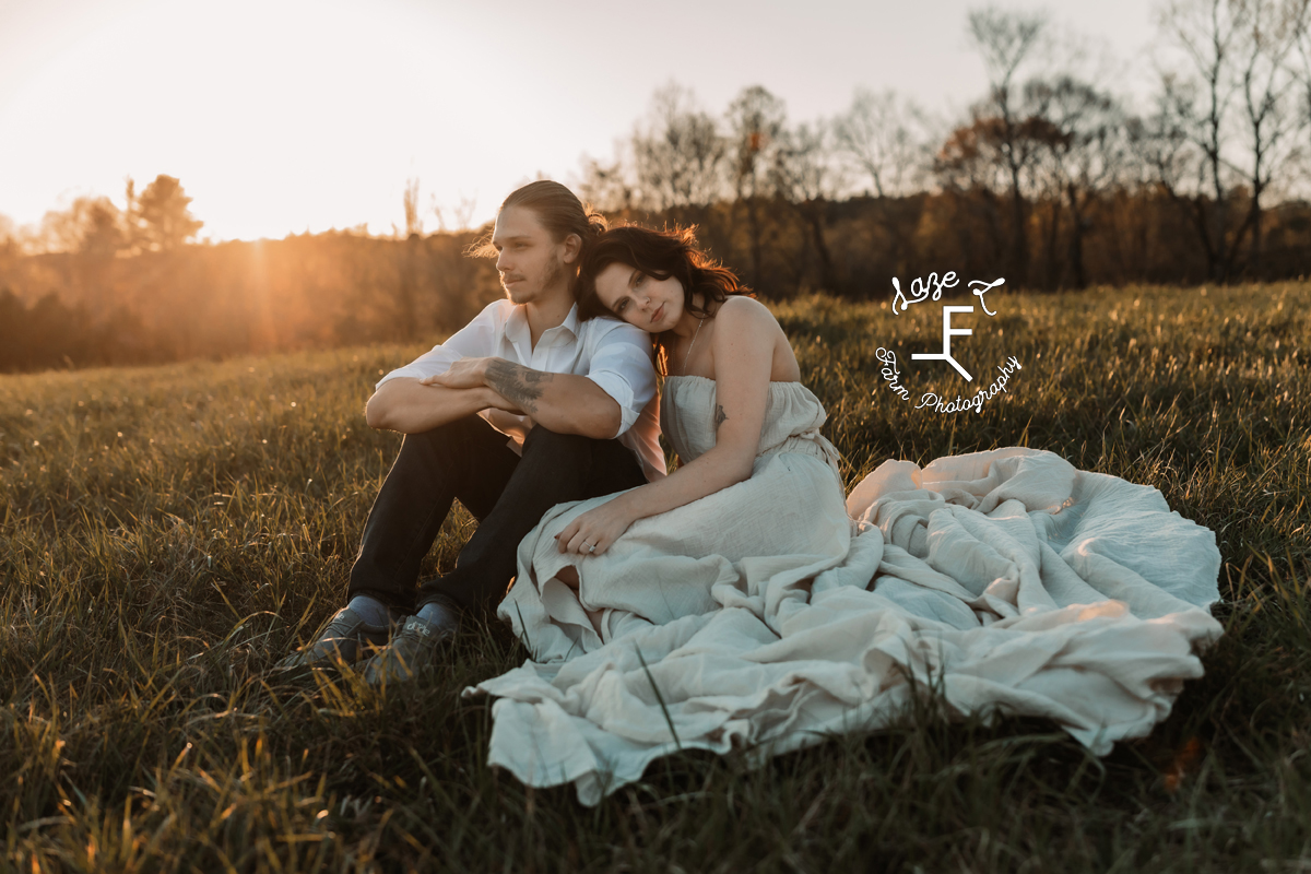 couple sitting on hill snuggling