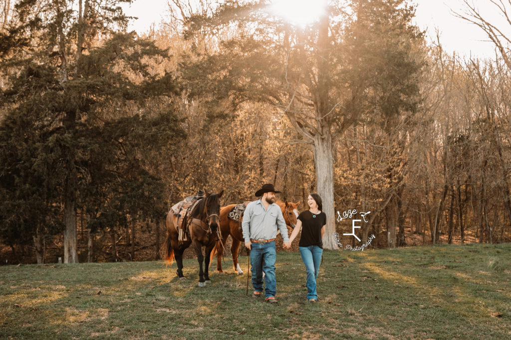 cowboy and wife walking with 2 horses