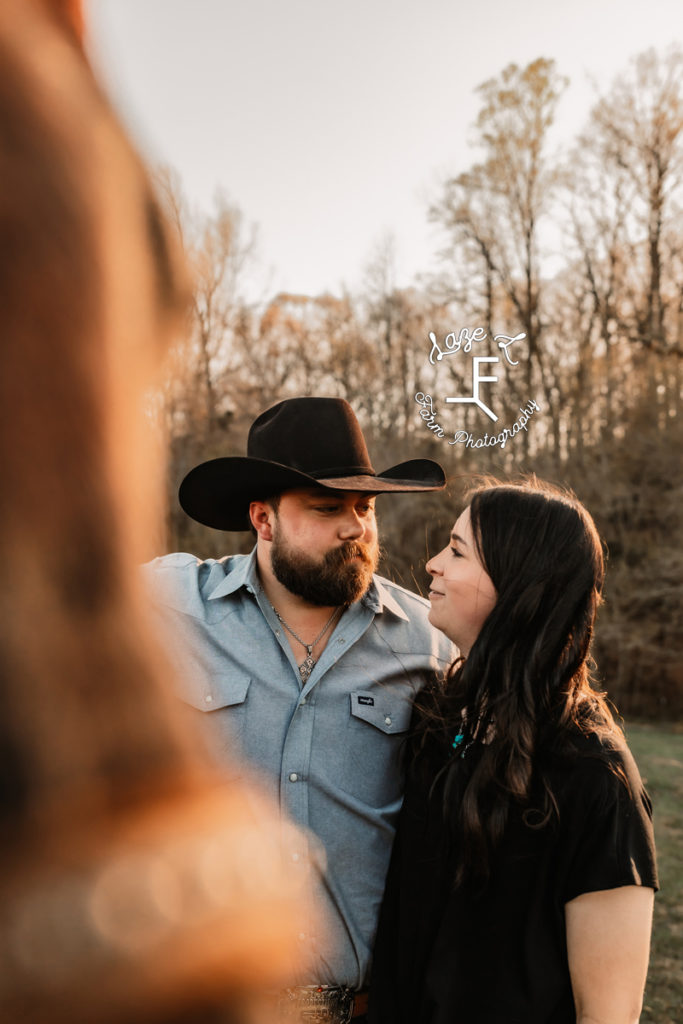 cowboy and wife with horse blurred in the foreground