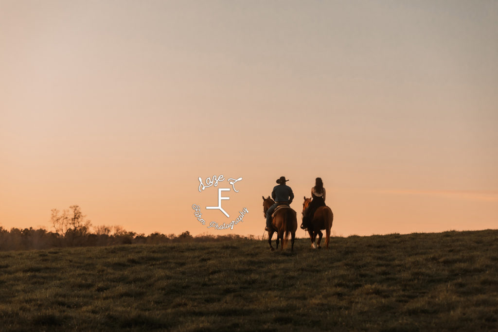 cowboy and wife riding into the sunset on a hill