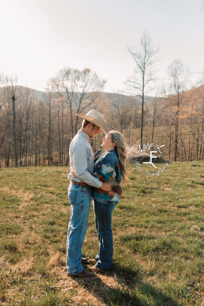 cowboy couple hugging in field