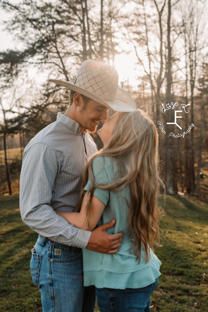 cowboy couple with sun behind them