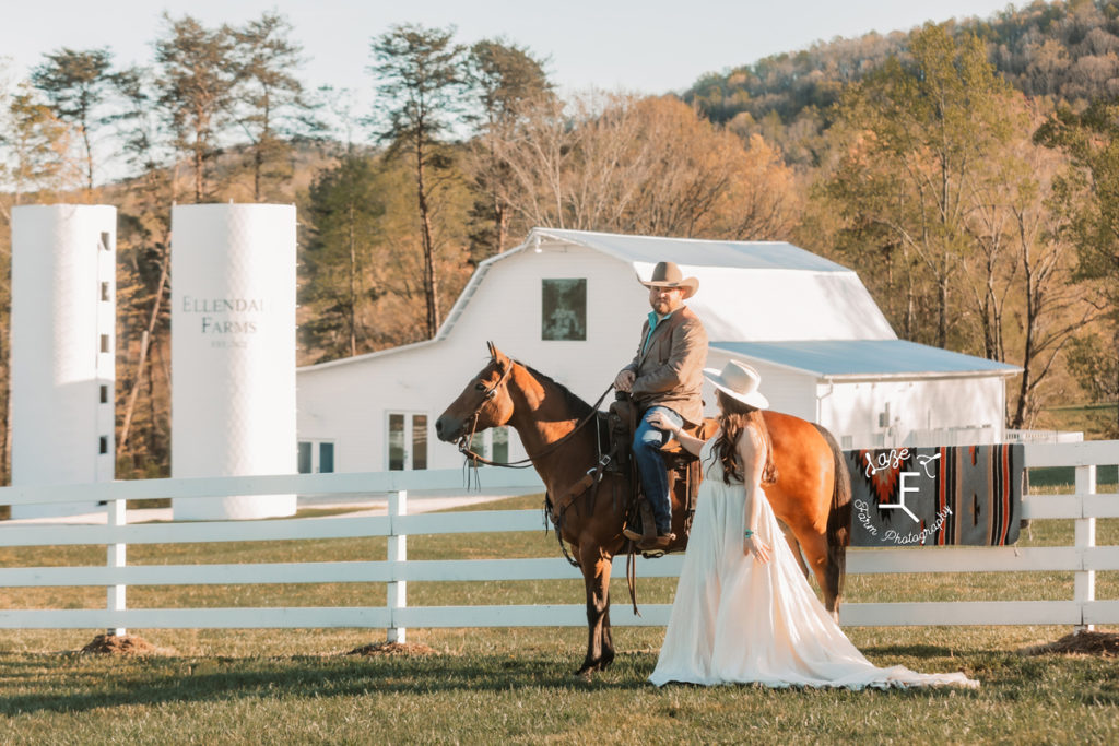 cowboy groom riding horse with western bride on ground