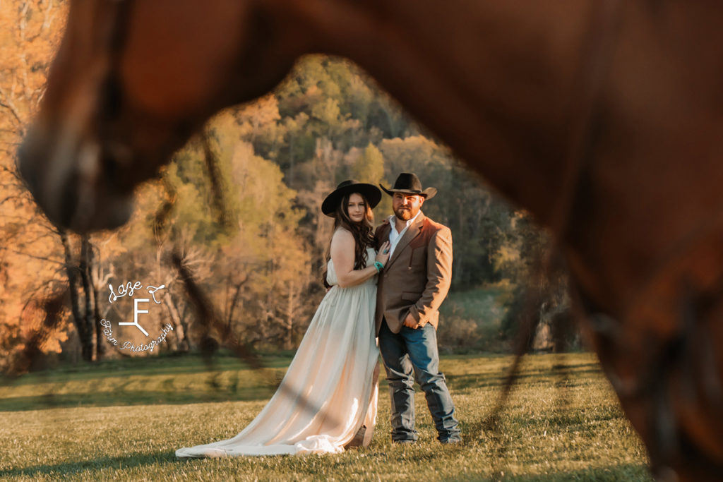 western couple framed by horse head and reins