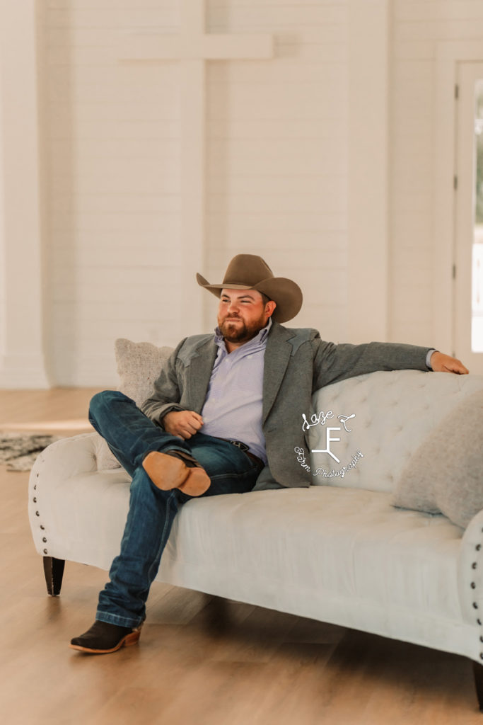 cowboy groom sitting on couch