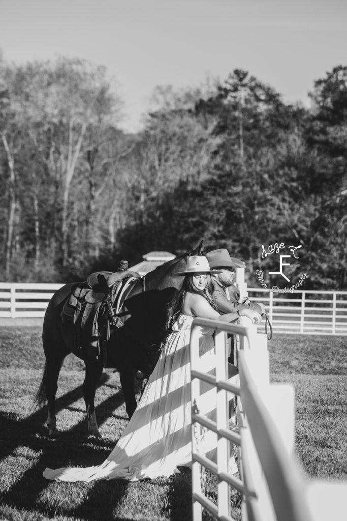 cowboy couple at fence in black and white