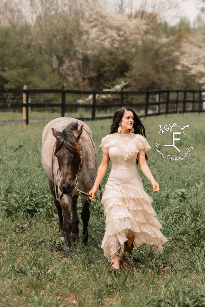 girl in vintage lace dress walking with horse
