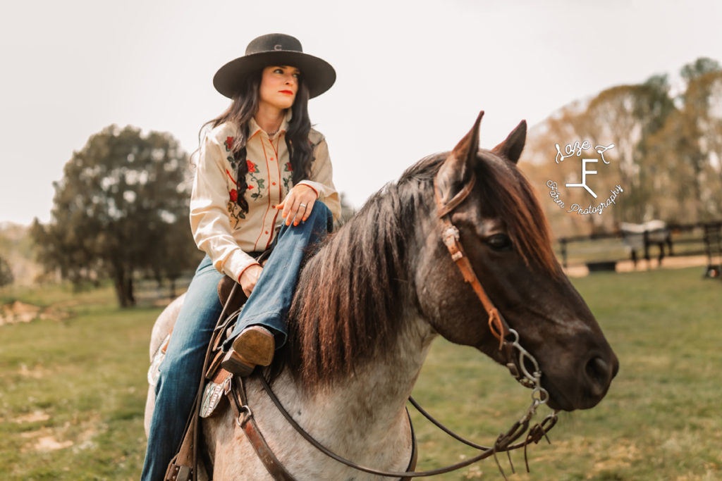 vintage cowgirl sitting on horse relaxing